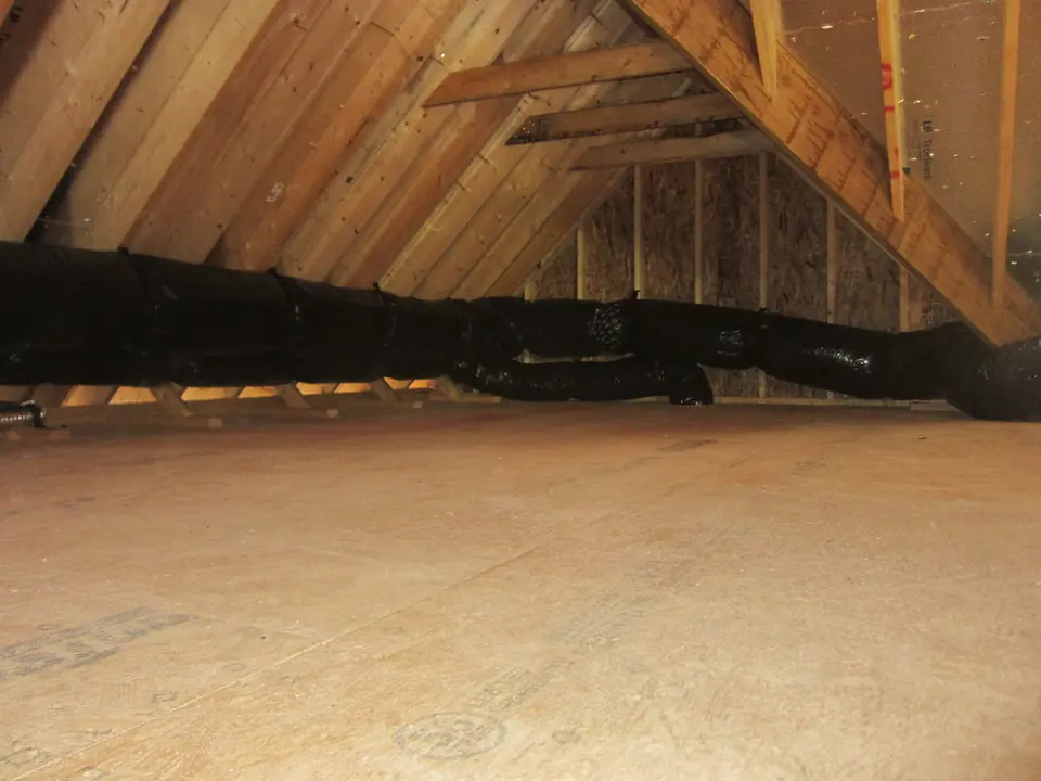 Insulated flex duct running across the floor of a residential attic