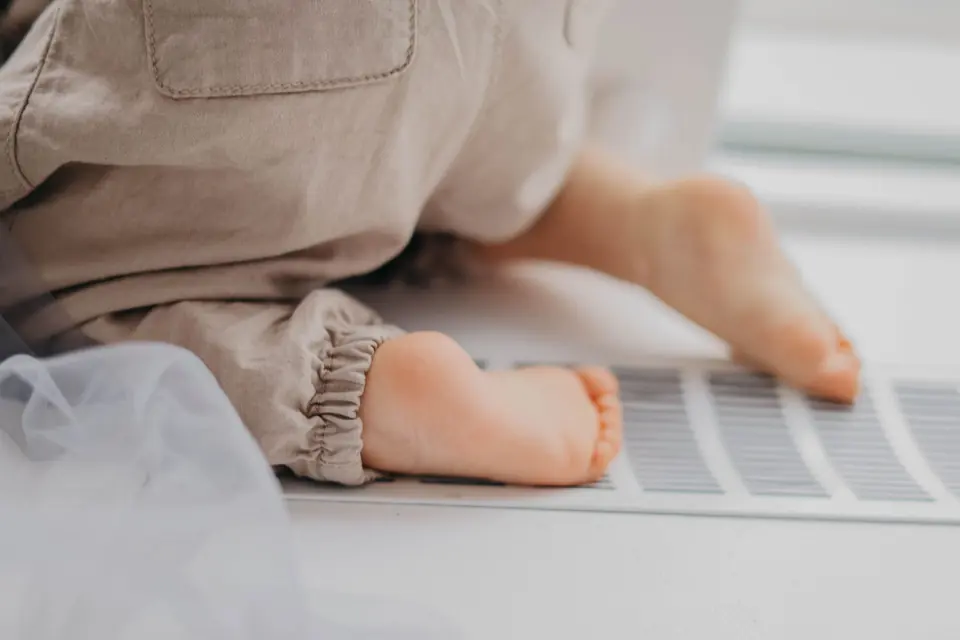 Bare feet warming over a floor heating register