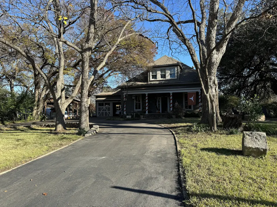 The stone Splitrock house behind oak trees in Old West Austin