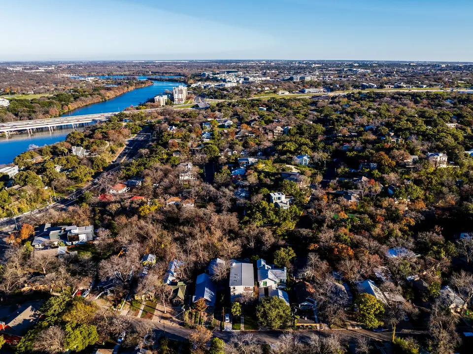 Aerial view of homes and tree cover in Travis Heights, Austin, facing east
